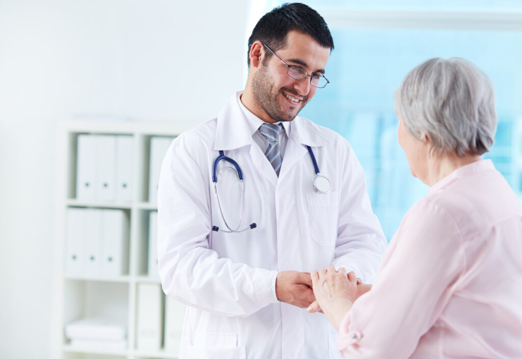 confident doctor looking at his senior patient while speaking to her SBI 300734052